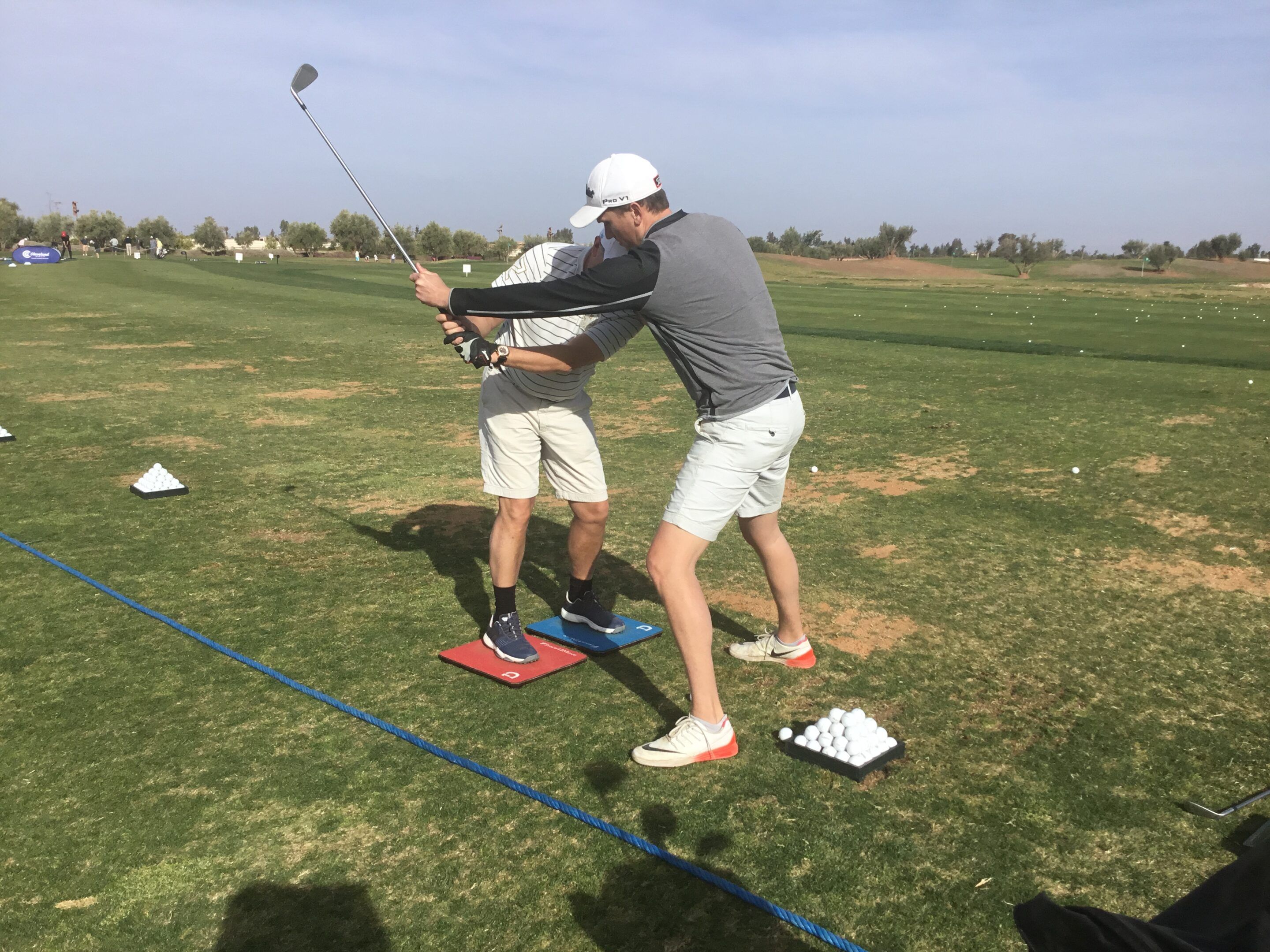 Edouard Davry guide le swing d’un élève pendant un cours de golf
