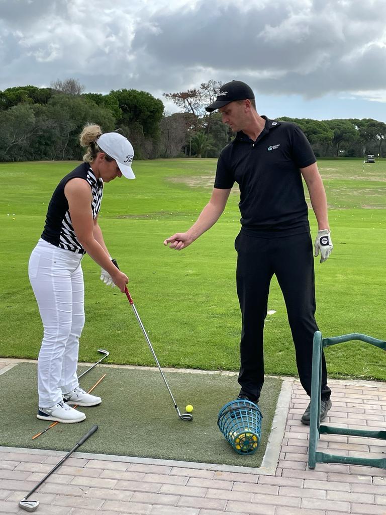 Séance d'entraînement au practice avec un professeur de golf