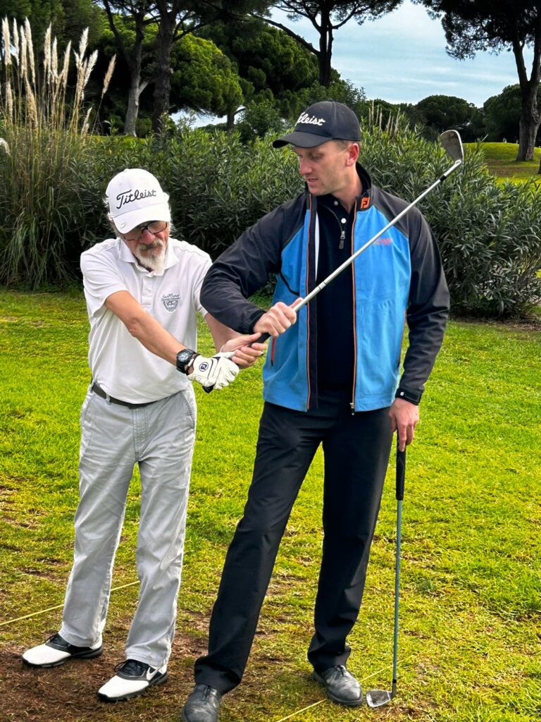 Edouard Davry corrige le geste d'un élève pendant un cours de golf
