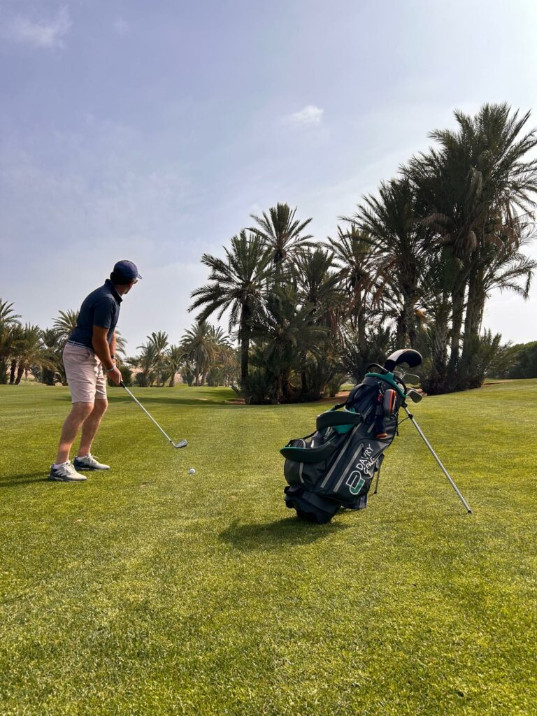 Sac de golf DavryGolf posé sur un fairway bordé de palmiers