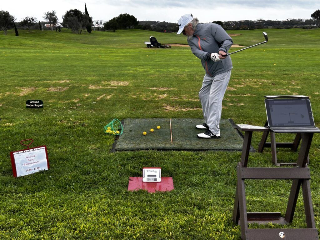 Un élève termine son swing au practice, analysé sur tablette
