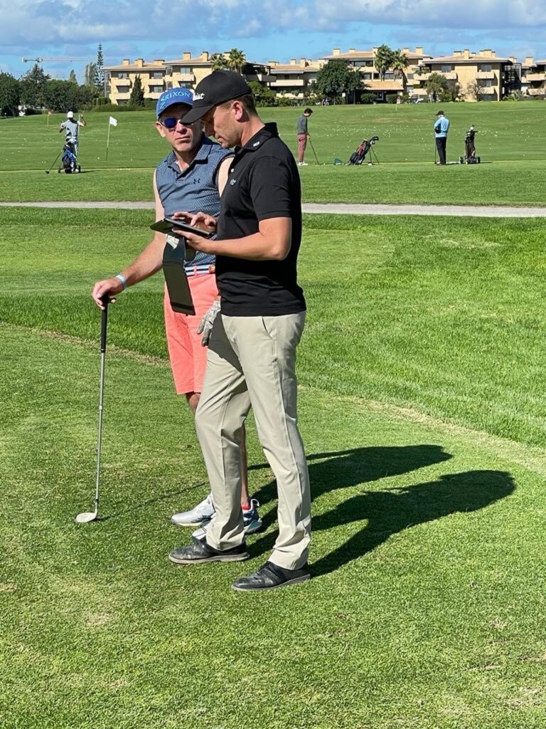 L'entraîneur de golf montre une vidéo sur tablette à un élève