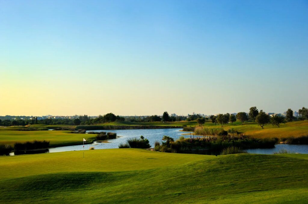Cours d'eau et fairway d'un golf de l'Algarve au coucher du soleil