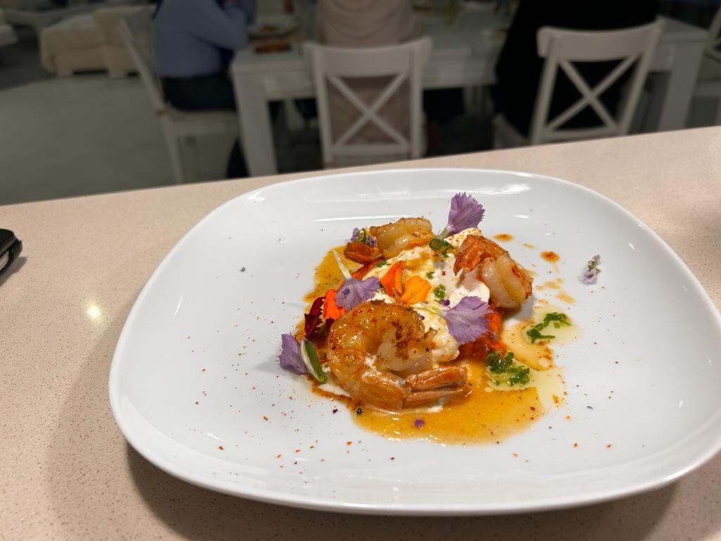Crevettes sautées, crème et fleurs comestibles
