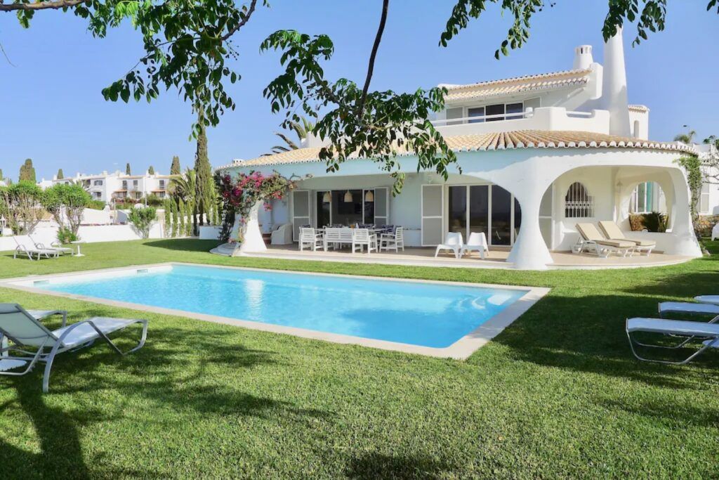 Façade blanche arrondie d'une villa avec piscine en Algarve