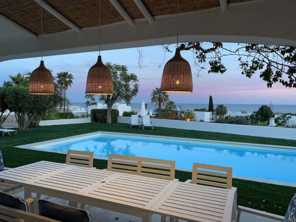 Table de terrasse, piscine et mer au crépuscule
