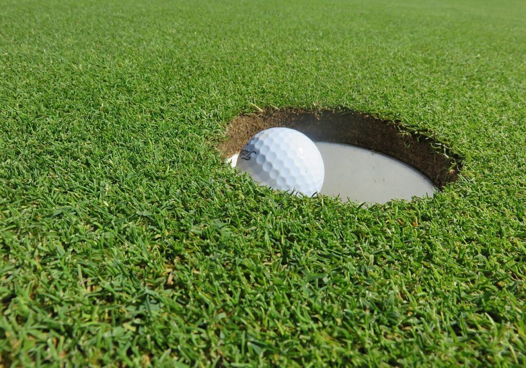 Une balle de golf au bord du trou, sur un green