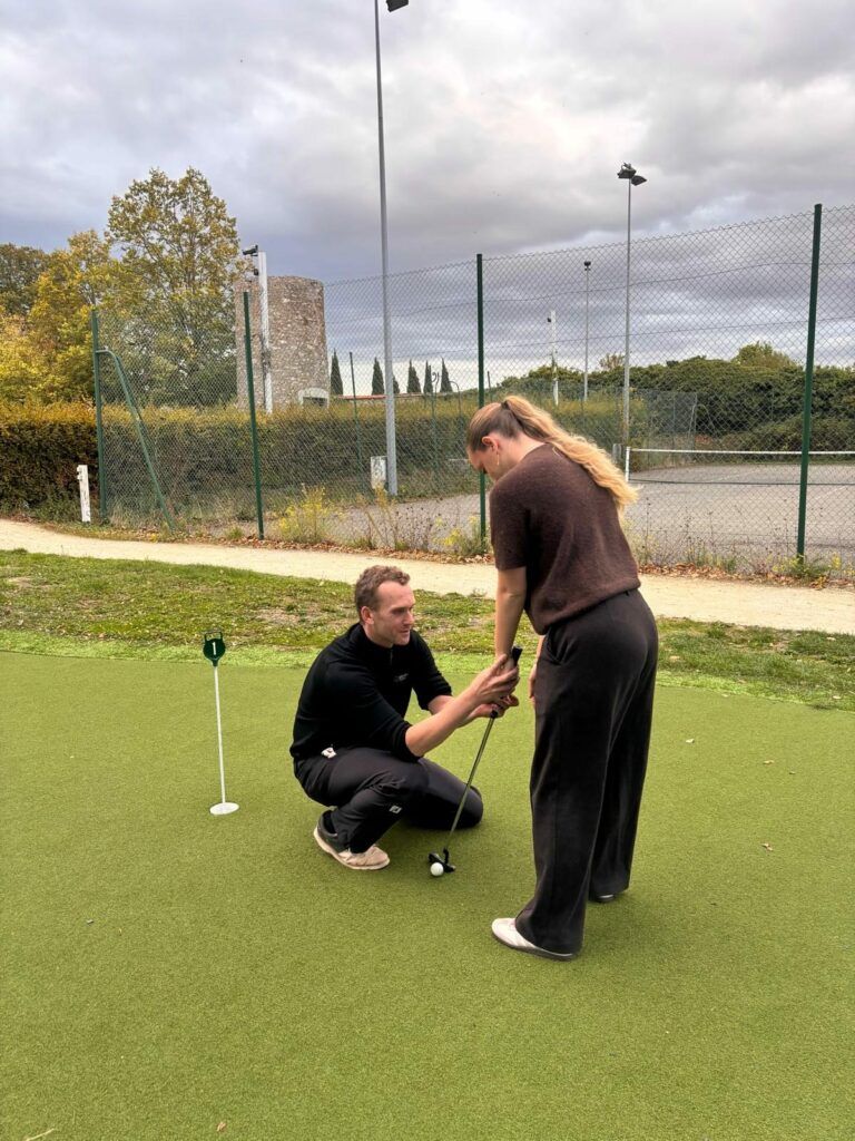 Edouard Davry, entraîneur de golf, accompagne une élève au putting au Parc du Coudray
