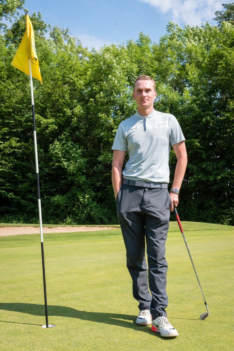 Edouard Davry, entraîneur de golf Pro PGA, debout près du drapeau sur un green