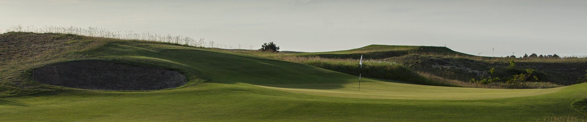 Un green du Links de Granville protégé par un bunker, terrain du petit jeu