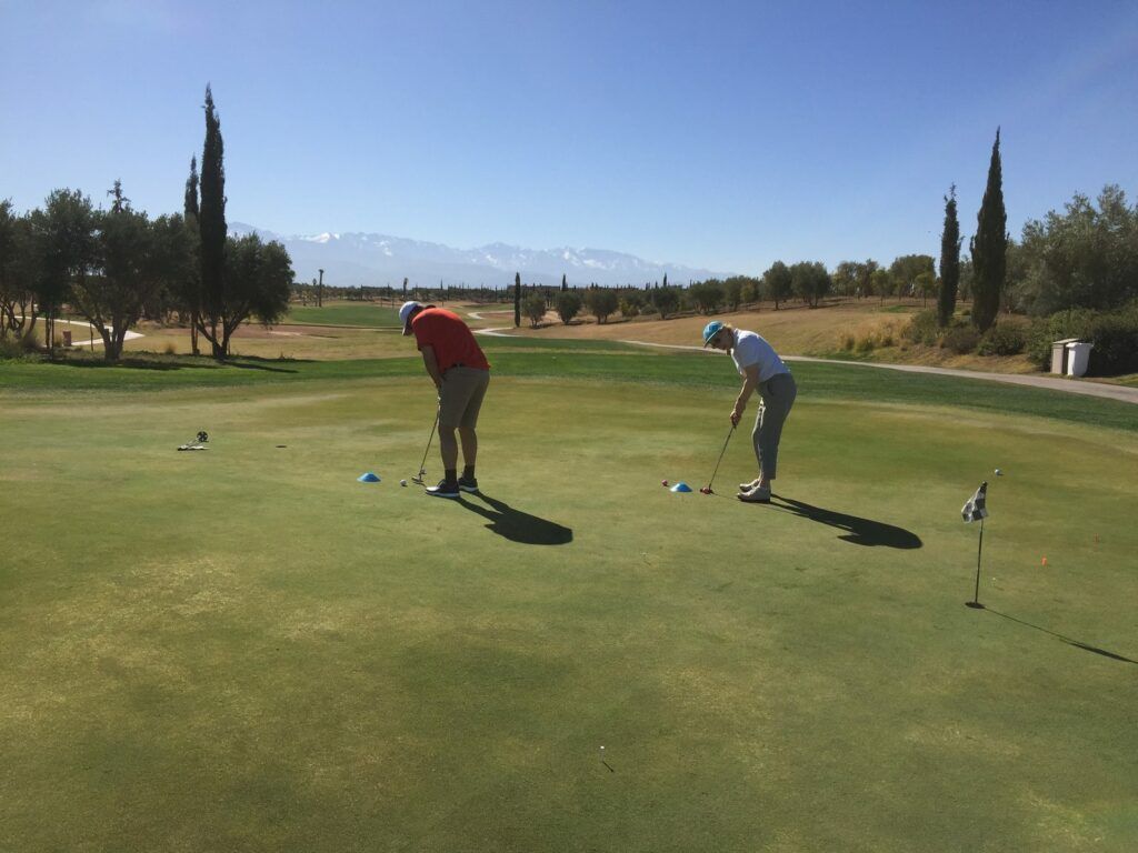 Deux stagiaires sur le putting green pendant un séjour golf encadré à Marrakech