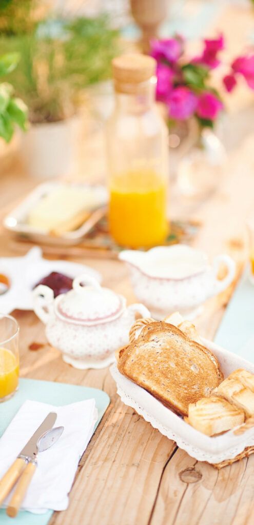 Table de petit-déjeuner avec jus d'orange, pain grillé et service à thé