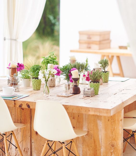 Table en bois dressée avec plantes aromatiques et bougies