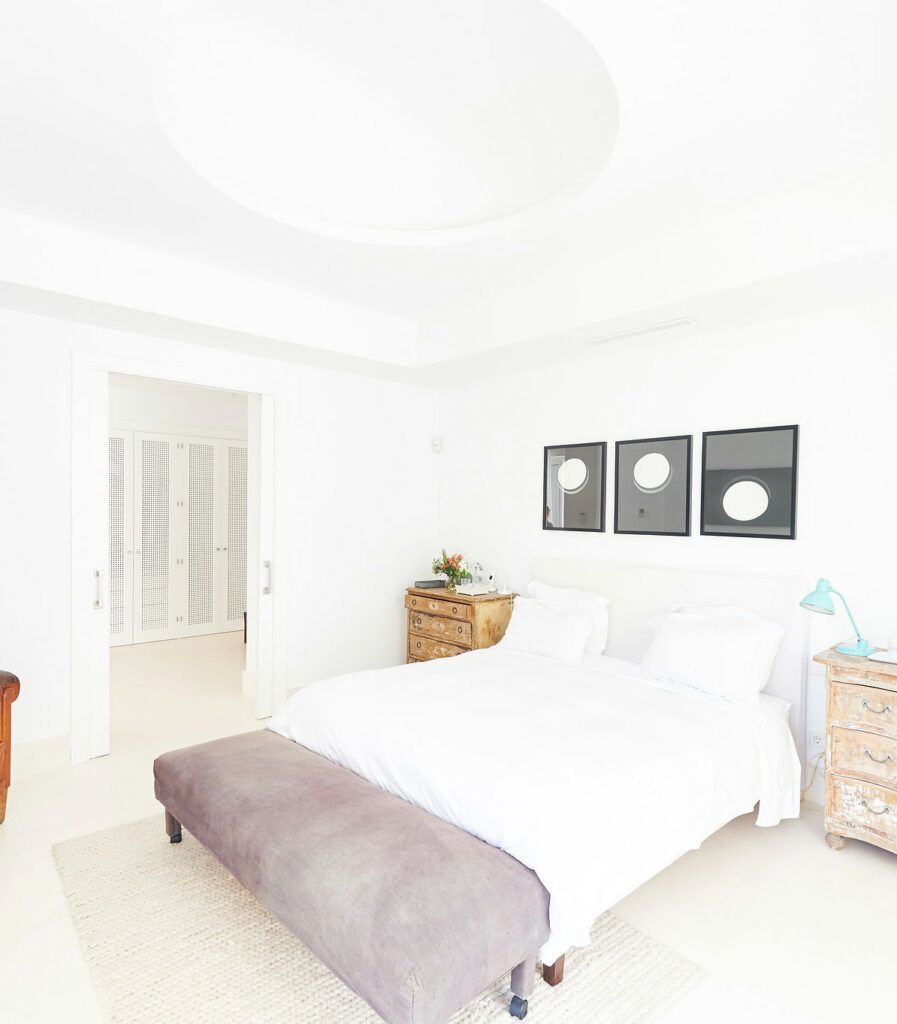 Chambre blanche avec lit double dans la villa