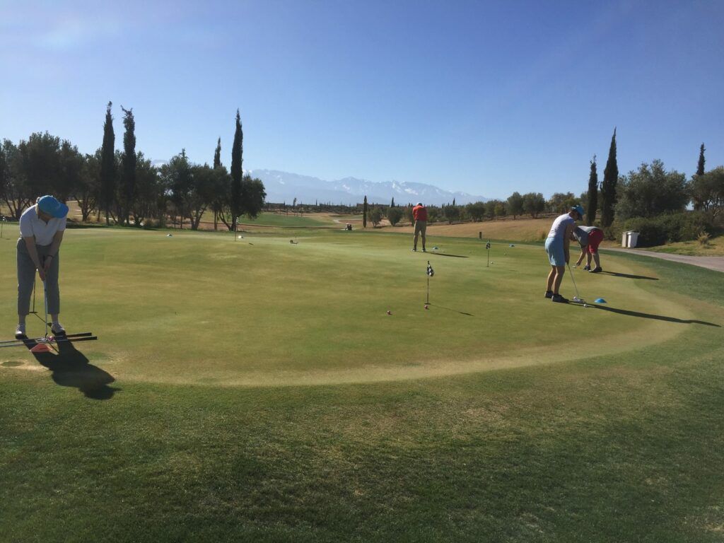 Stagiaires à l’entraînement sur le putting green pendant un stage de golf à Marrakech