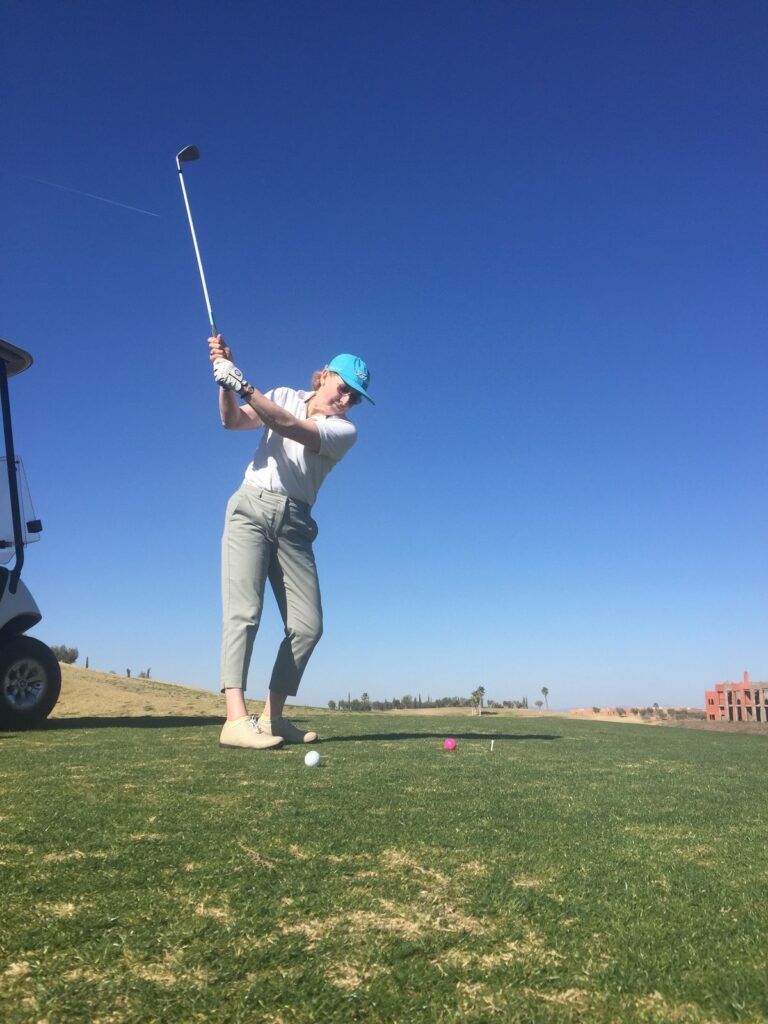 Swing d’une stagiaire sous le ciel bleu pendant un stage de golf à Marrakech